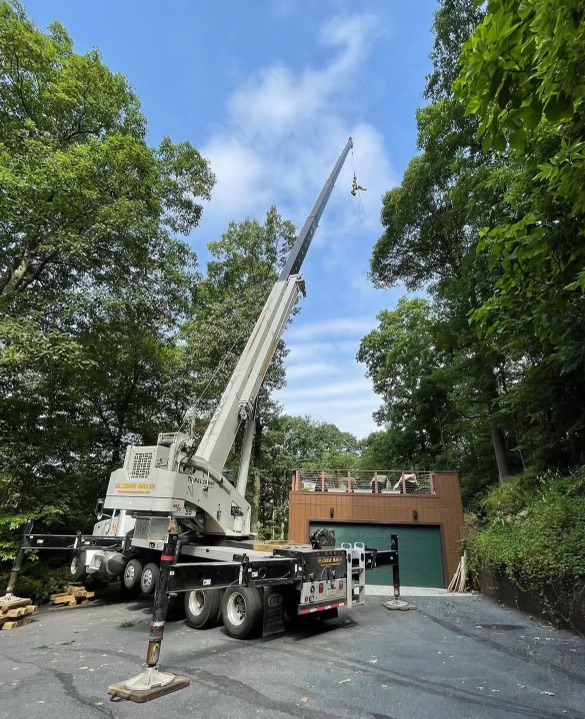 Hahn's Tree Service crane lifting a large section of tree from a residential property near Pen Argyl PA