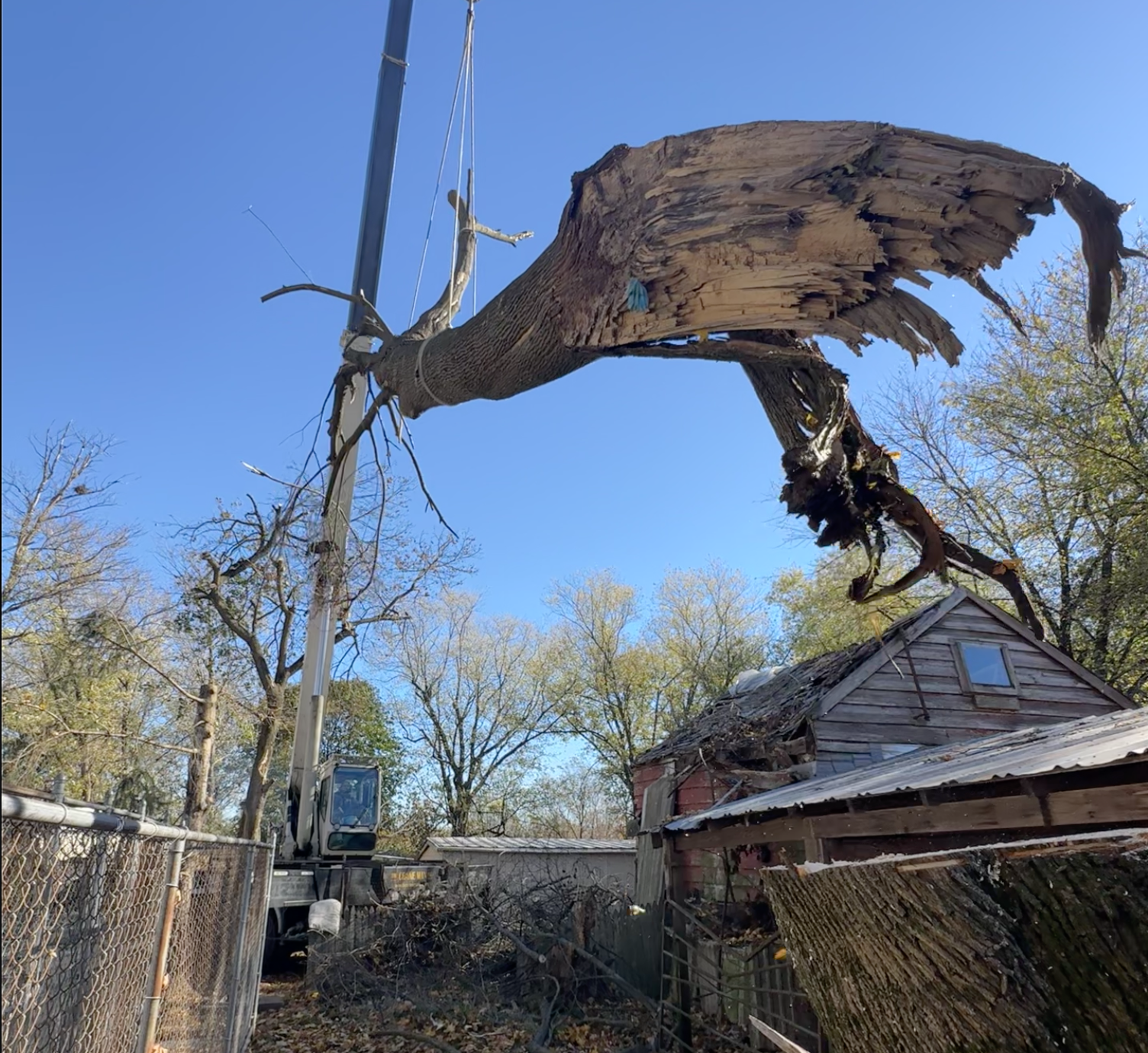 Hahn's Tree Service crane removing a large rotted trunk section on a property in Mount Bethel PA