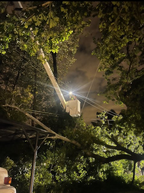 Hahn's Tree Service bucket truck working under lights at night on an emergency storm call